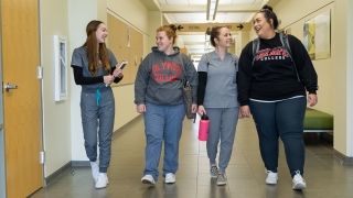 Four students walking down a hallway