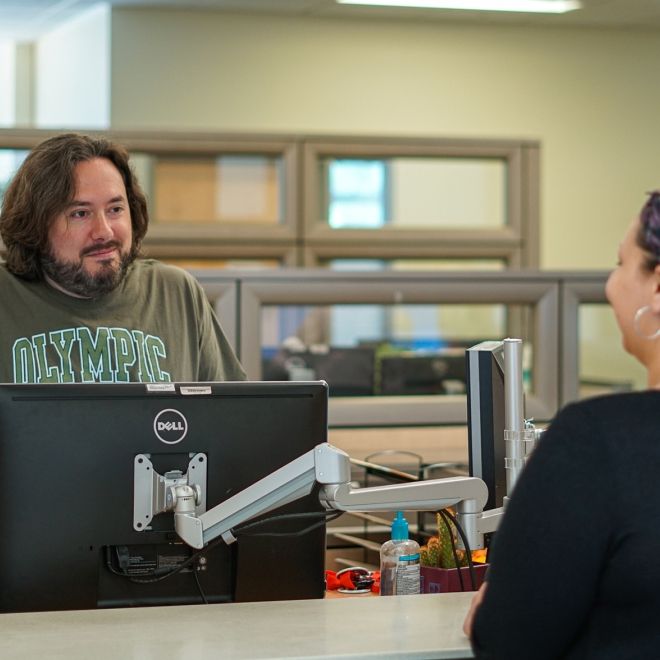 Male employee with student at counter.