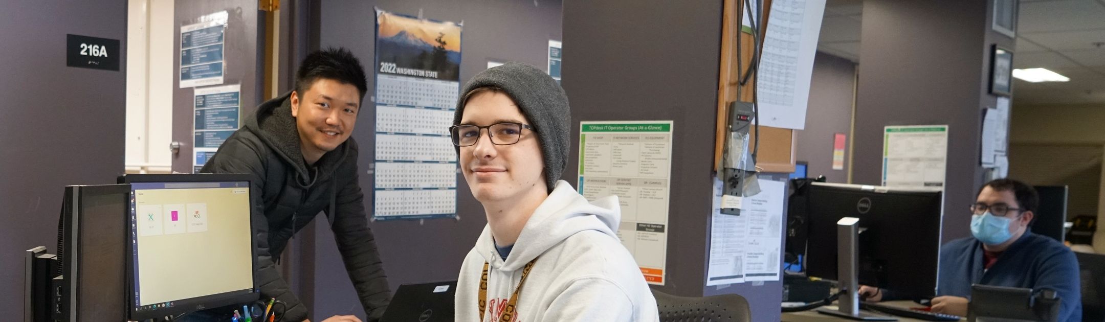 IT Help Desk staff sitting at computer