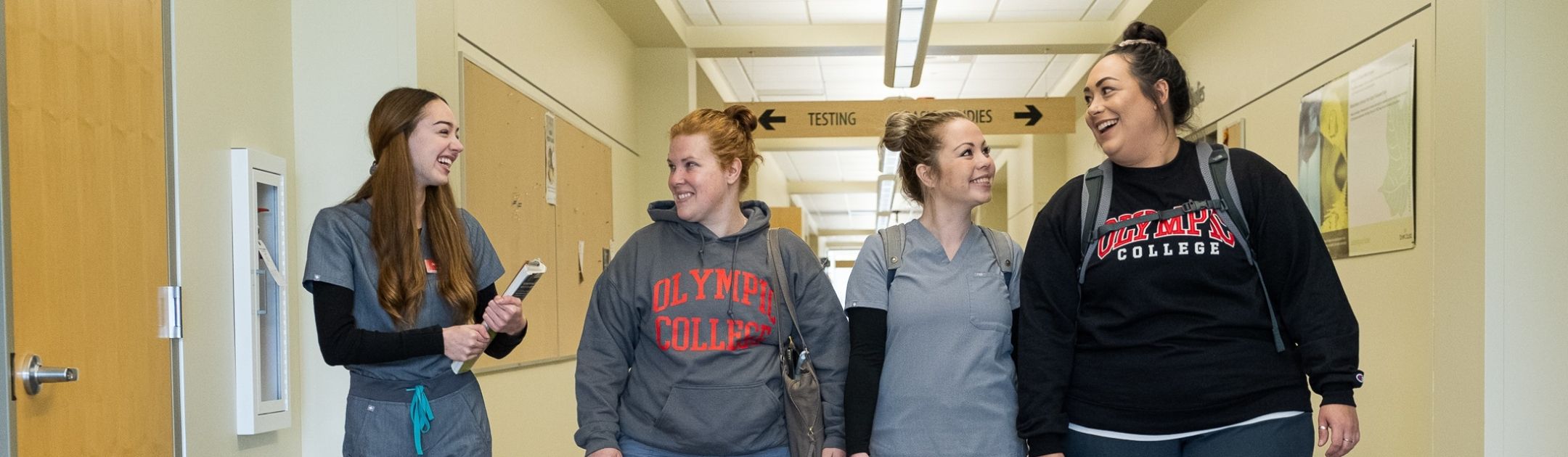 Four students walking down a hallway